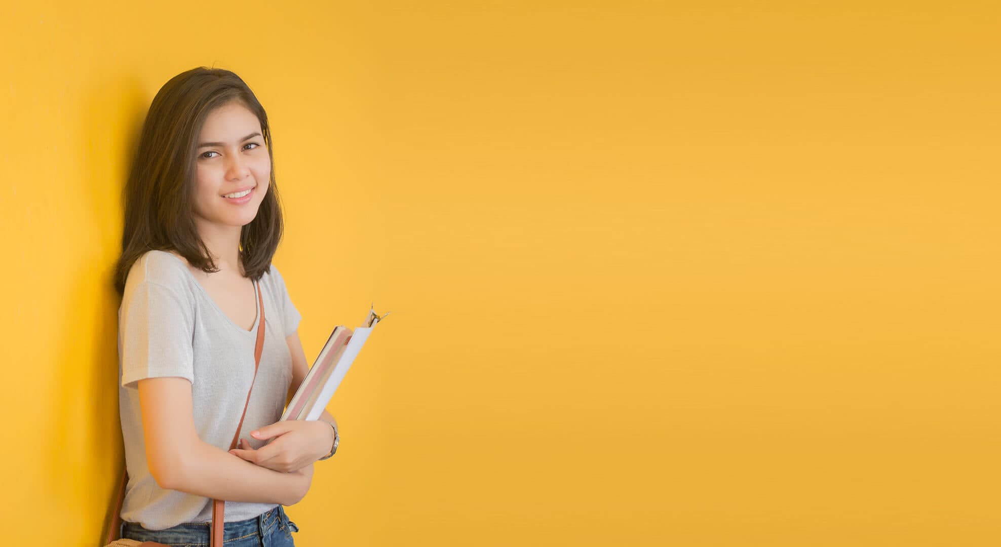 Student standing with textbooks